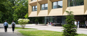 Young people walk past a building with a golden façade