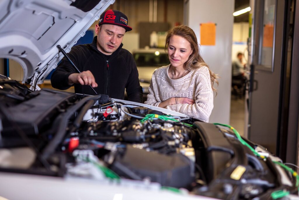 Zwei Studierende arbeiten an einem Motor 