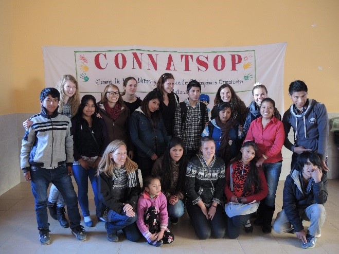 Eine bunt gemischte Gruppe von Menschen, darunter Erwachsene und Kinder, posiert für ein Foto im Innenbereich der Hochschule Coburg. Auf einem Banner im Hintergrund steht „CONNATSOP“, was darauf schließen lässt, dass sie sich zu einer Veranstaltung oder einem Meeting versammelt haben.