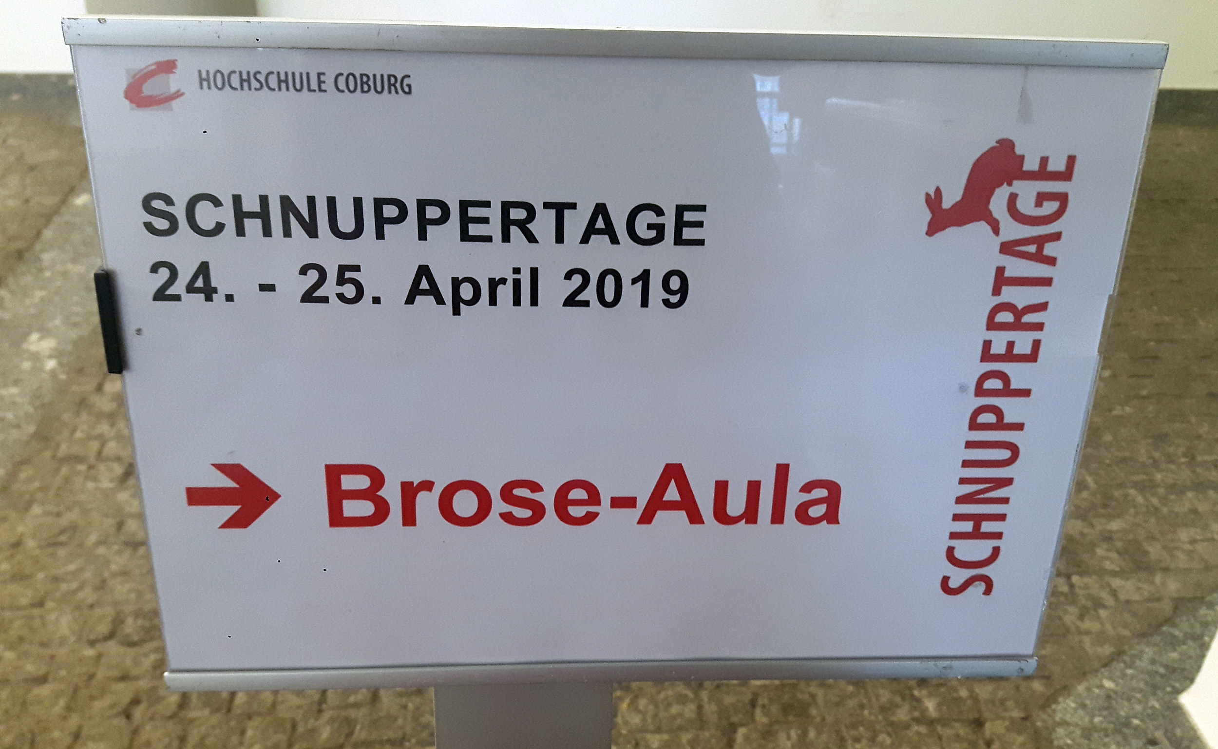 An der Hochschule Coburg informiert ein Schild über die Schnuppertage am 24. und 25. April 2019 und ein roter Pfeil weist den Weg zur Brose-Aula.