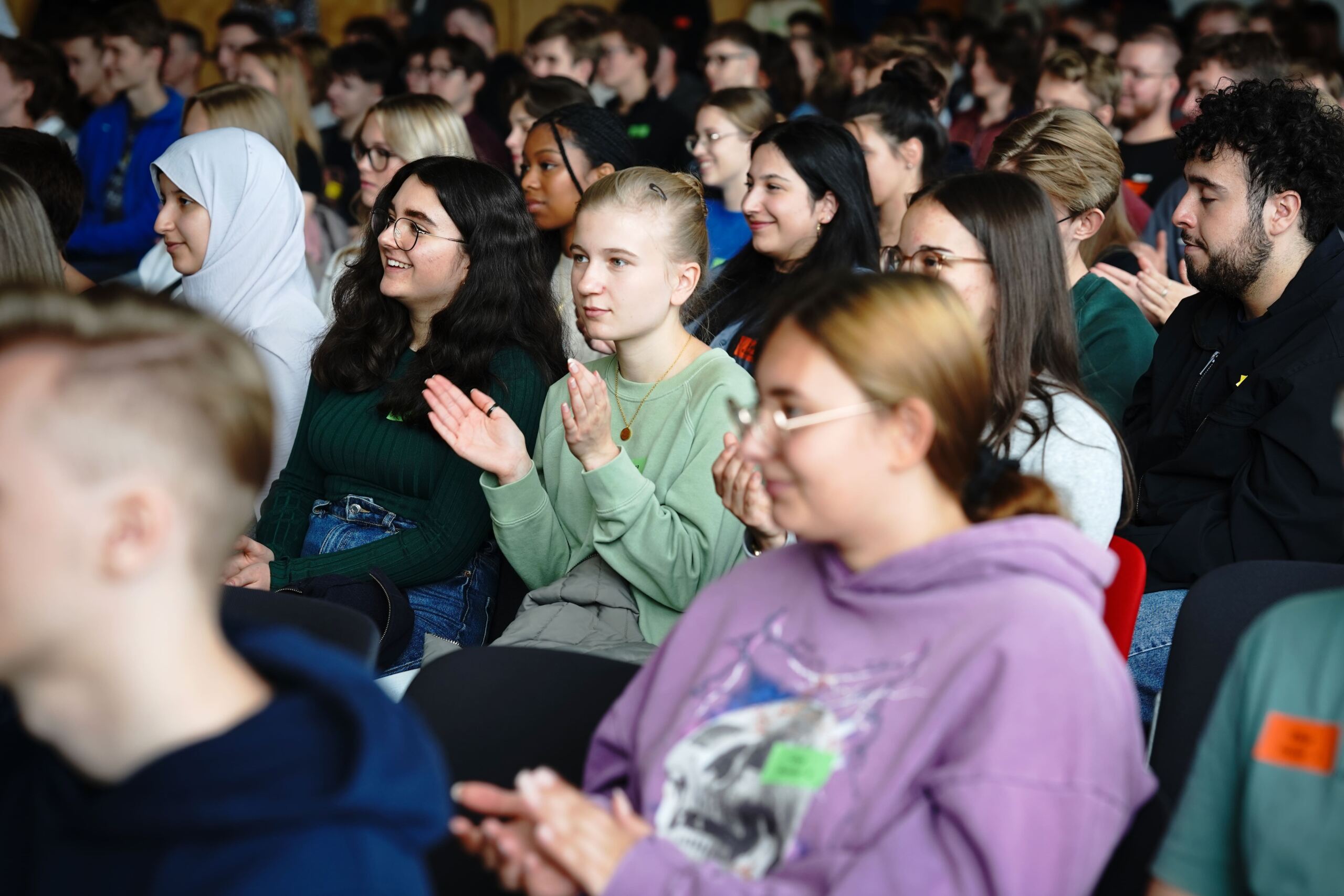 Studis applaudieren und lachen in der Aula