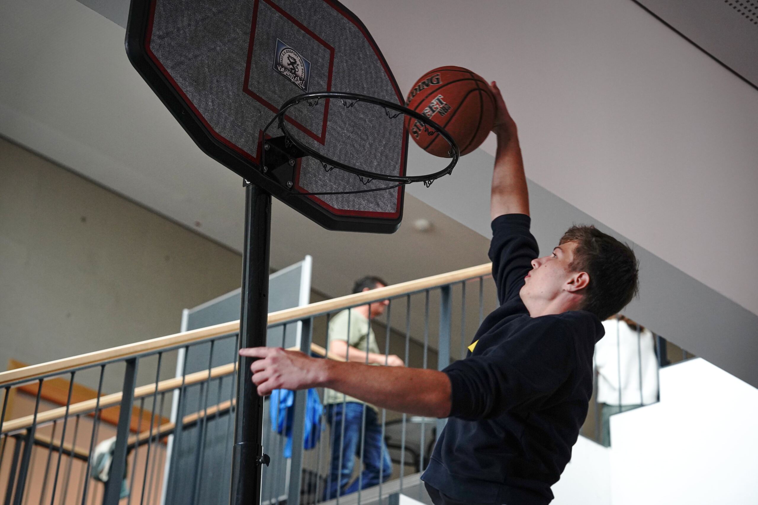 Studi wirft Basketball in den Basketballkorb