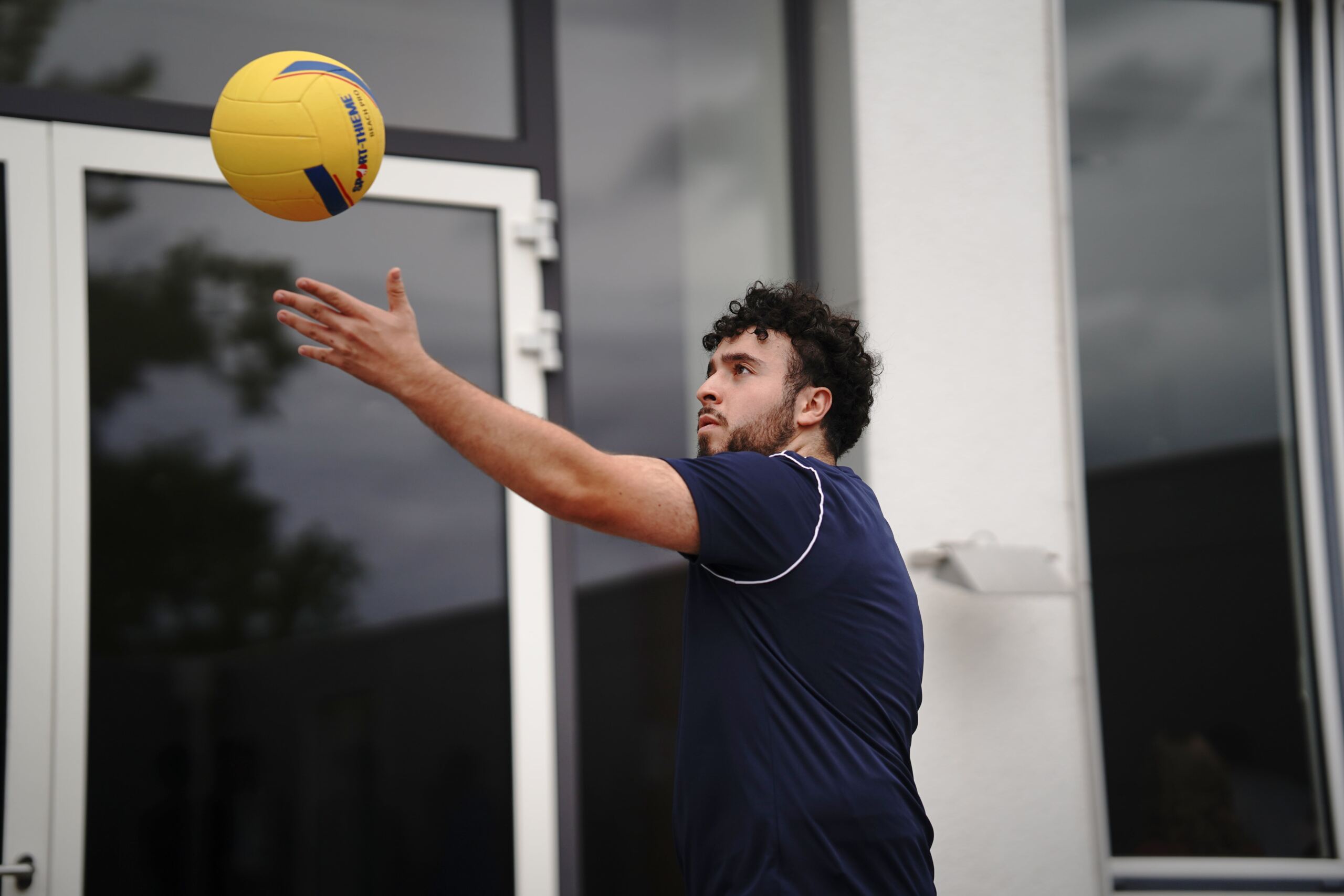 Studi schlägt einen Volleyball ins Feld